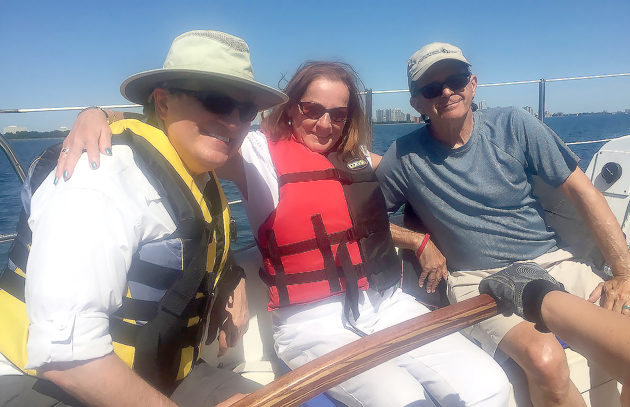 Three smiling people sailing on lake michigan 